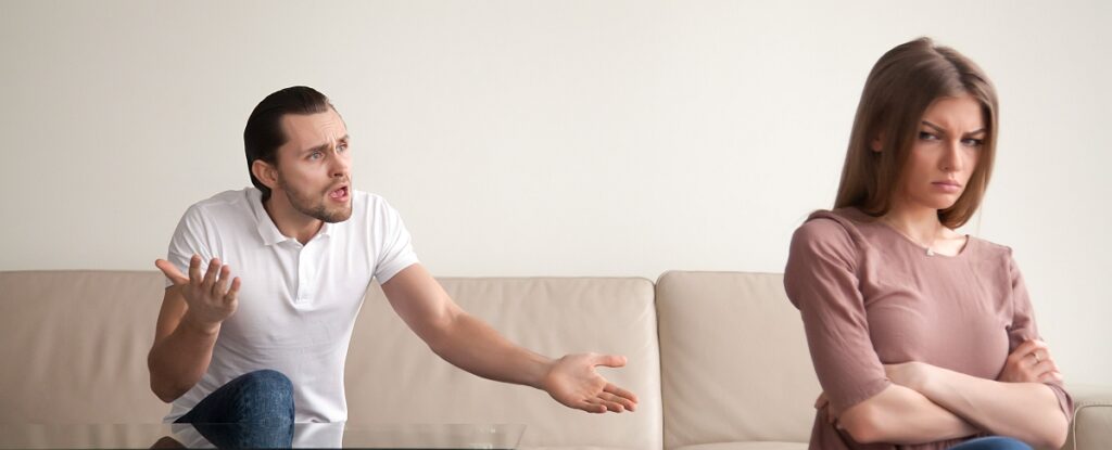 Young couple quarrelling, angry man shouting, woman offended